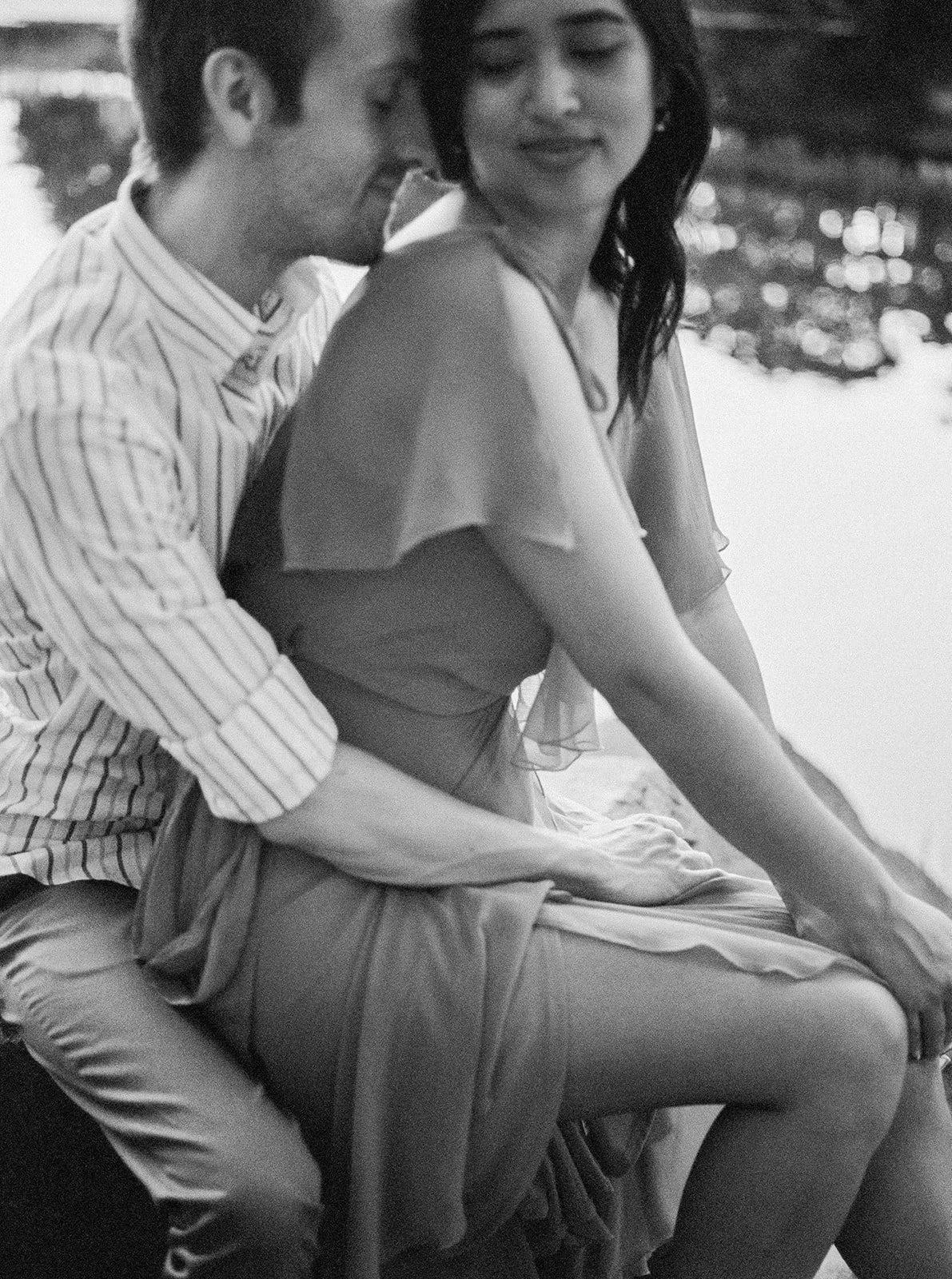 Couple sitting by the lake, relaxed pose during a quiet sunset engagement session in Oregon