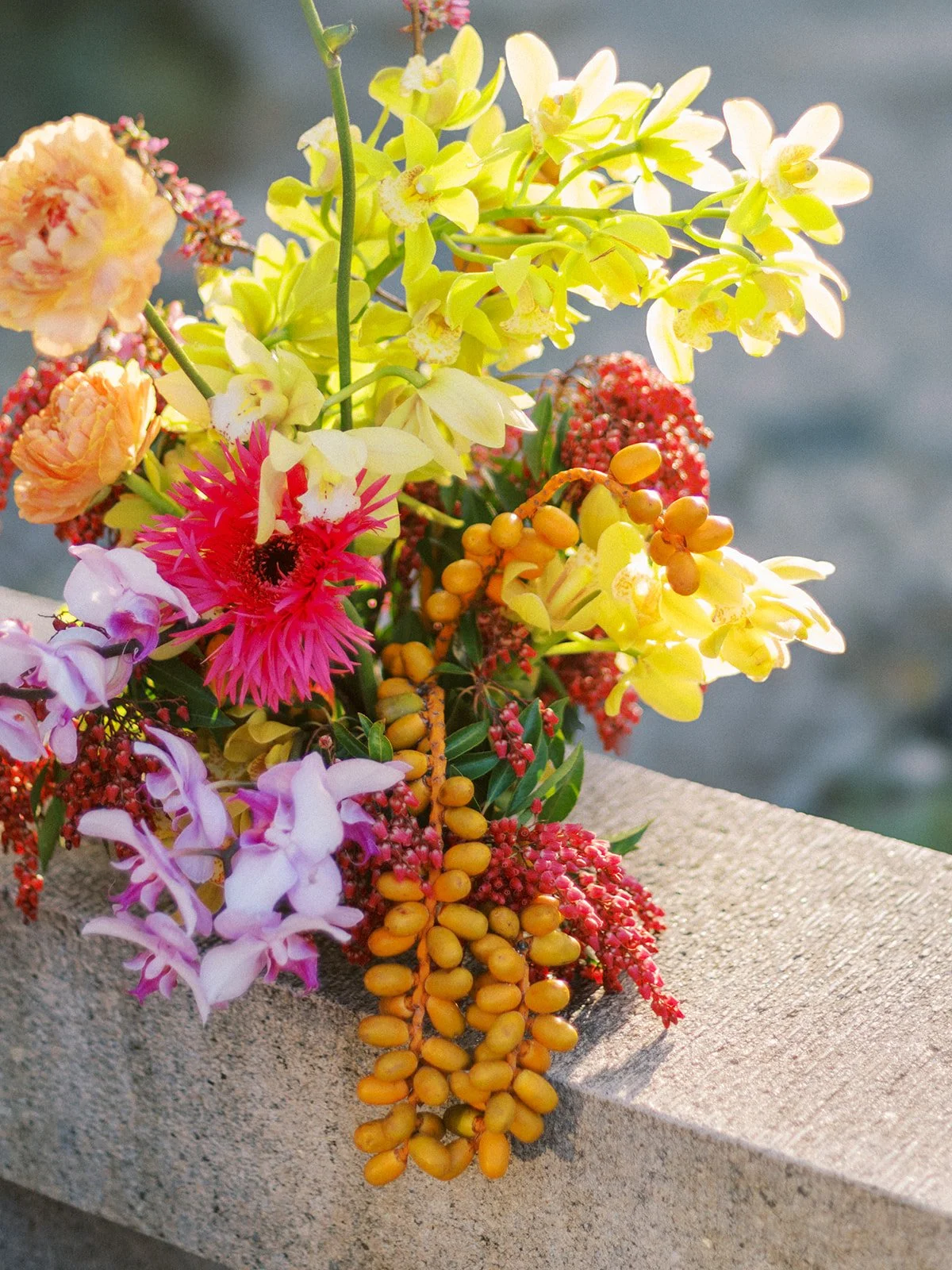 Bright floral arrangement resting on stone architecture inside Lan Su Chinese Garden.