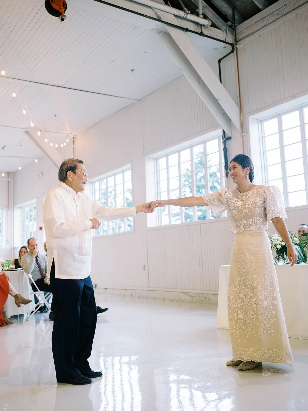 Bride dancing with her father inside the Pearson Air Museum hangar as guests watch during the wedding reception.