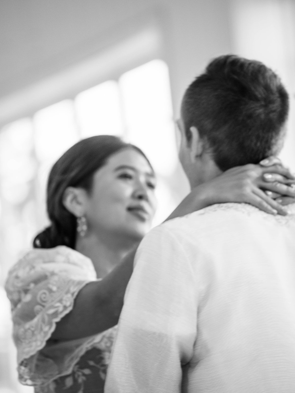 Black and white close-up of the bride embracing the groom during a quiet moment at their Pearson Air Museum wedding.