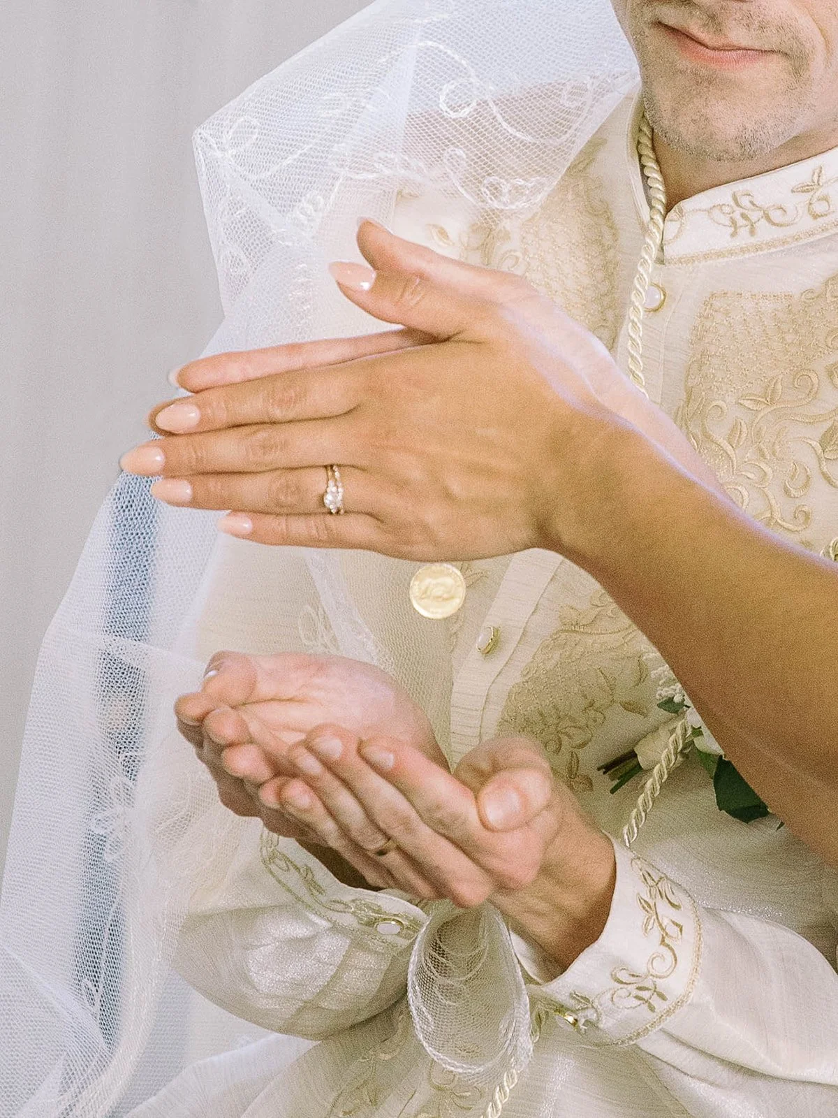 Close-up of a Filipino wedding tradition as coins are dropped into the bride’s hands during the ceremony.
