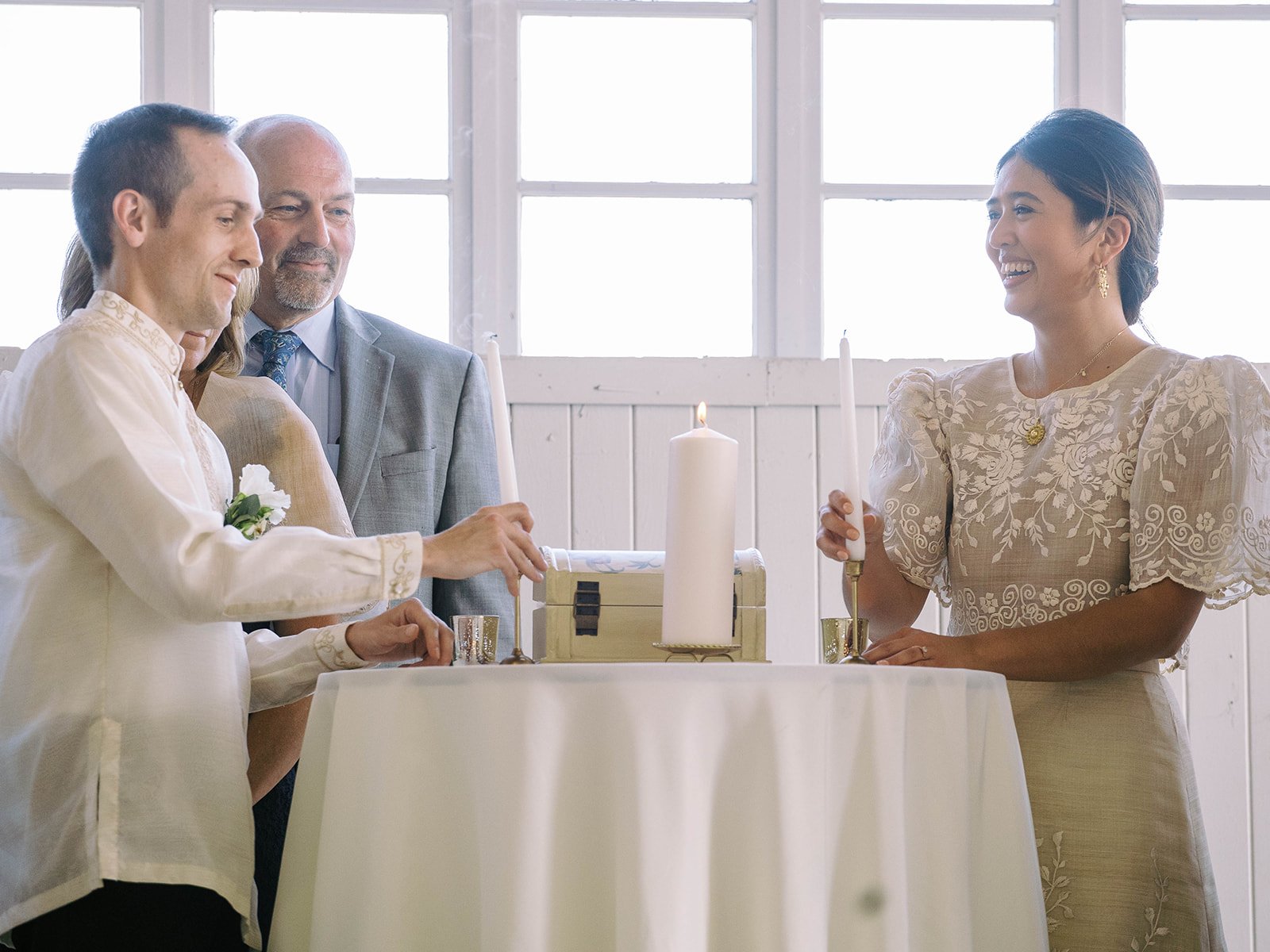 Bride and groom participating in a traditional wedding ritual with candles inside the Pearson Air Museum hangar.