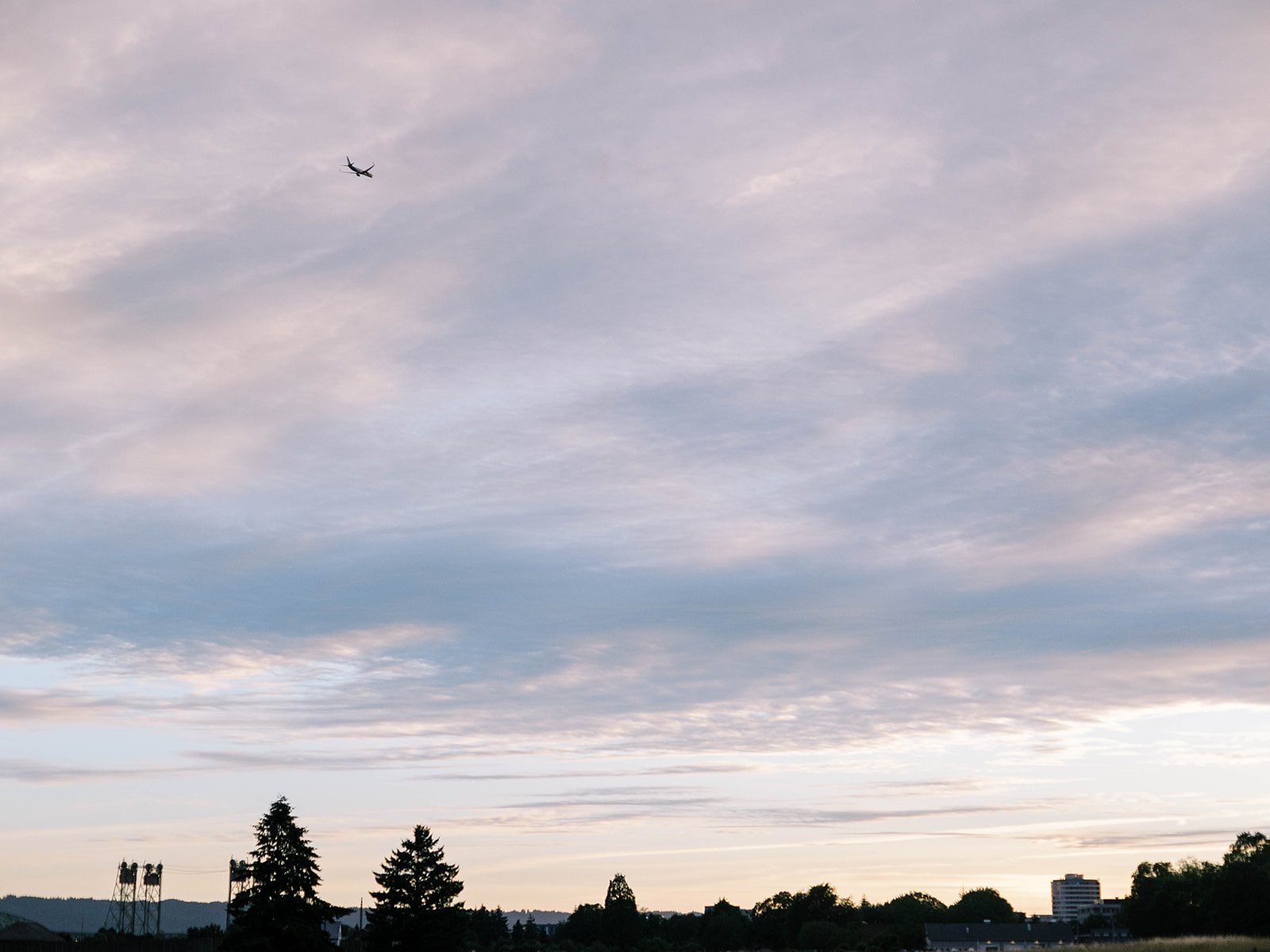 Soft evening sky over Pearson Air Museum with an airplane flying overhead during a wedding celebration.