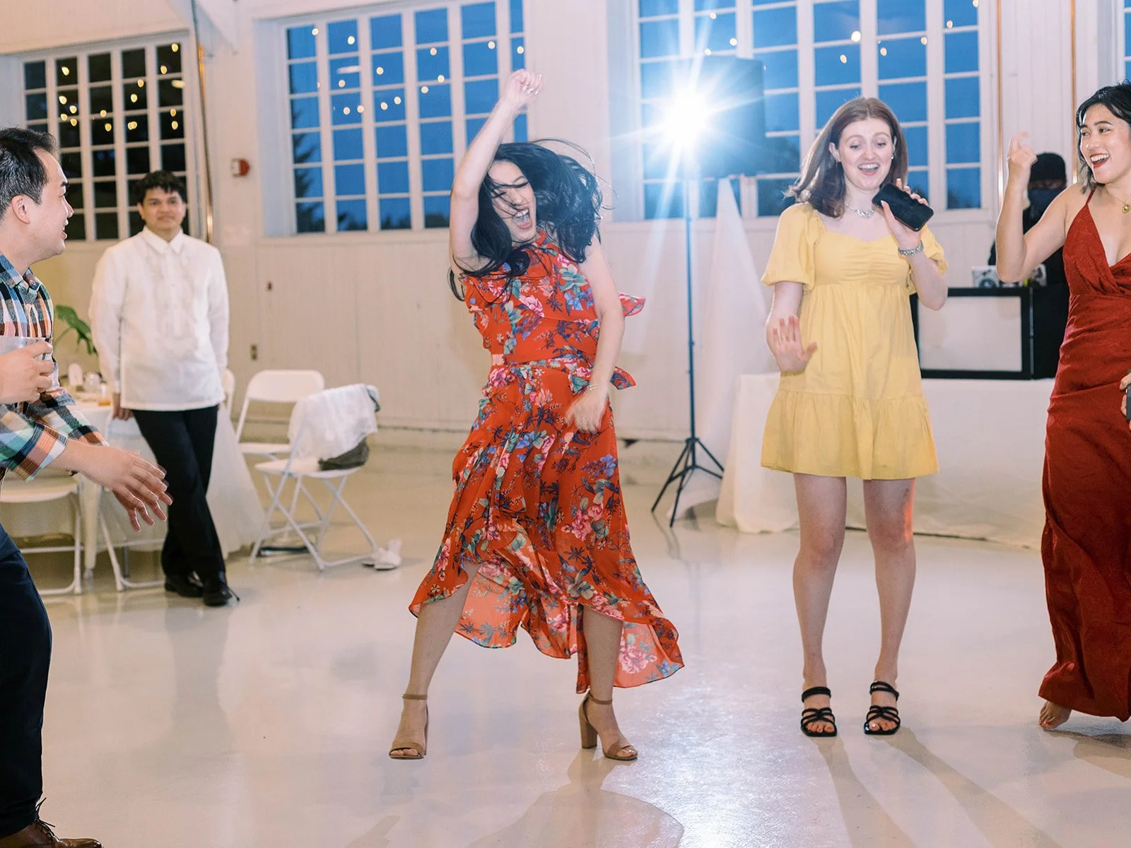 Guests dancing joyfully on the dance floor inside the Pearson Air Museum hangar during the wedding reception.