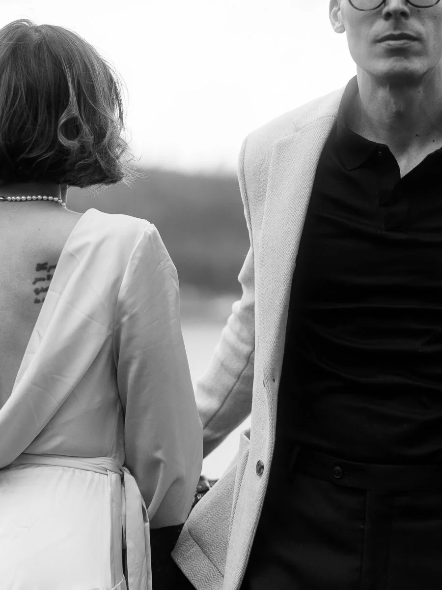 Close view of the couple from behind, highlighting the bride’s open-back dress and pearl necklace against the Columbia Gorge landscape.