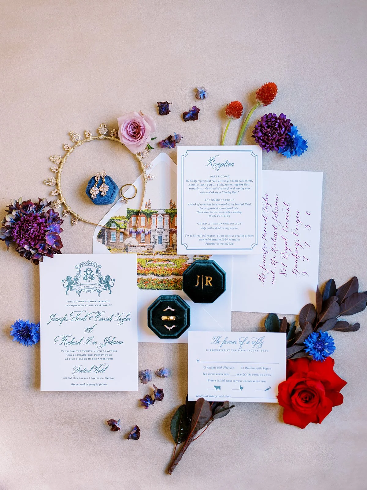 Wedding invitation suite with rings, earrings, floral accents, and vintage illustration arranged on textured background.