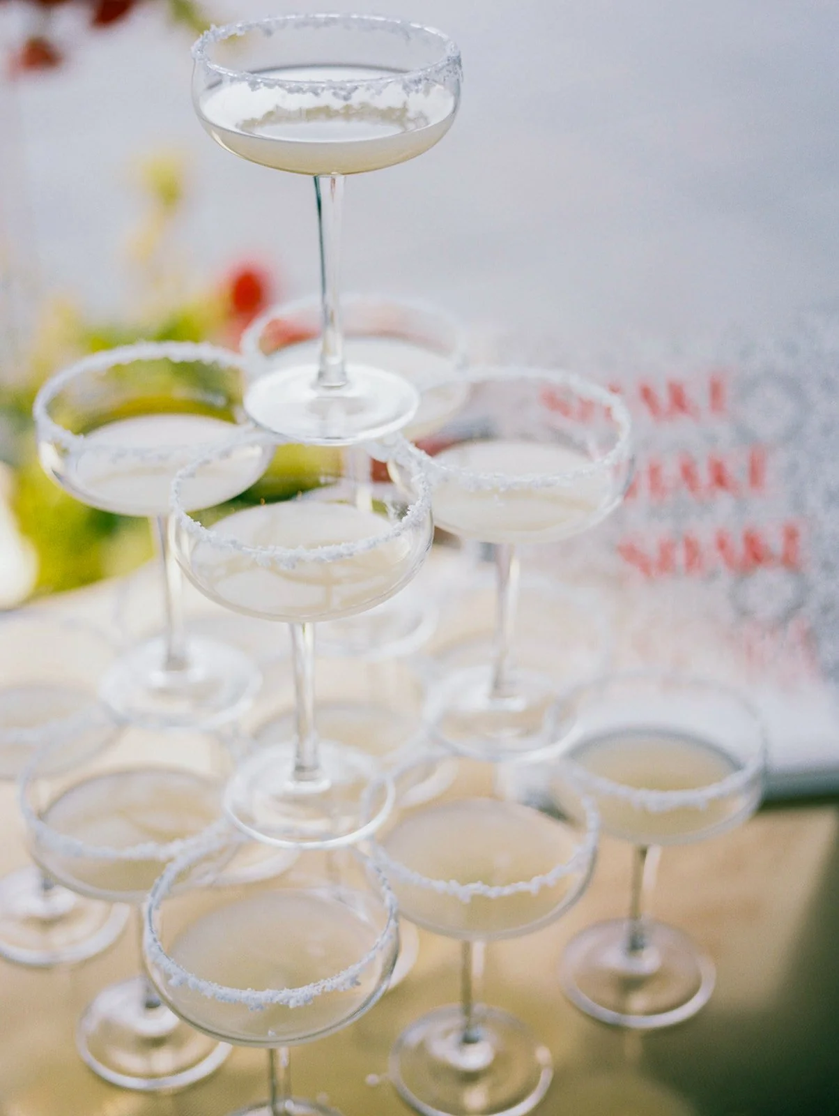 Stacked coupe glasses with sugar rims forming margarita tower at modern Ironlight wedding reception