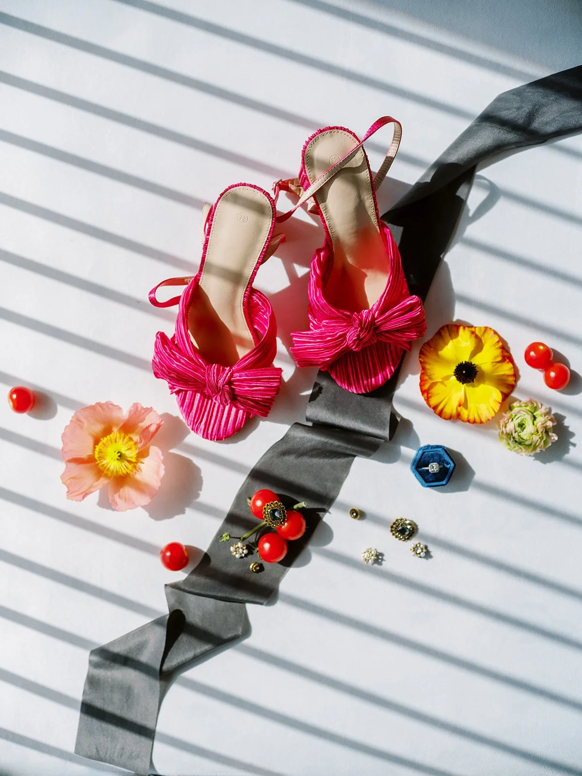 Pink pleated bridal shoes with bow detail styled with ribbon, jewelry, and flowers for Portland wedding details