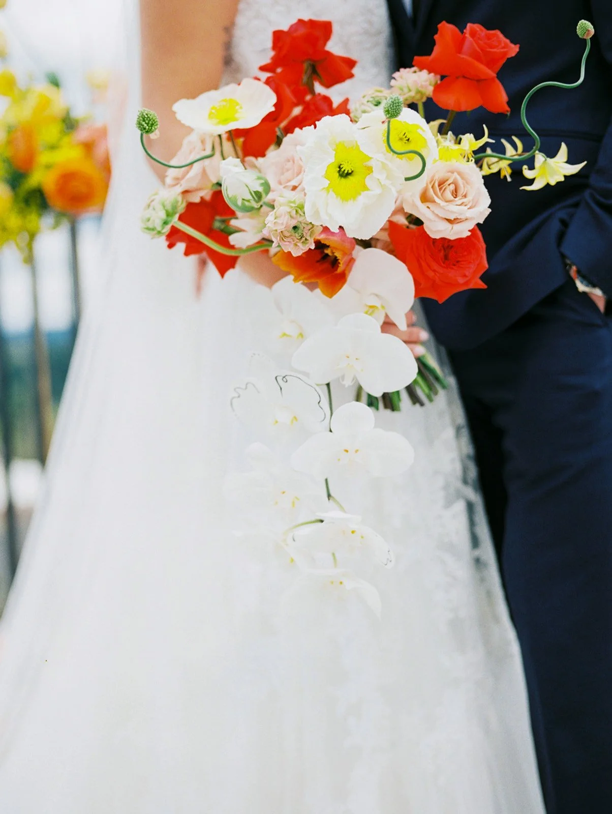 Close-up of bridal bouquet with orchids, roses, and bright seasonal blooms