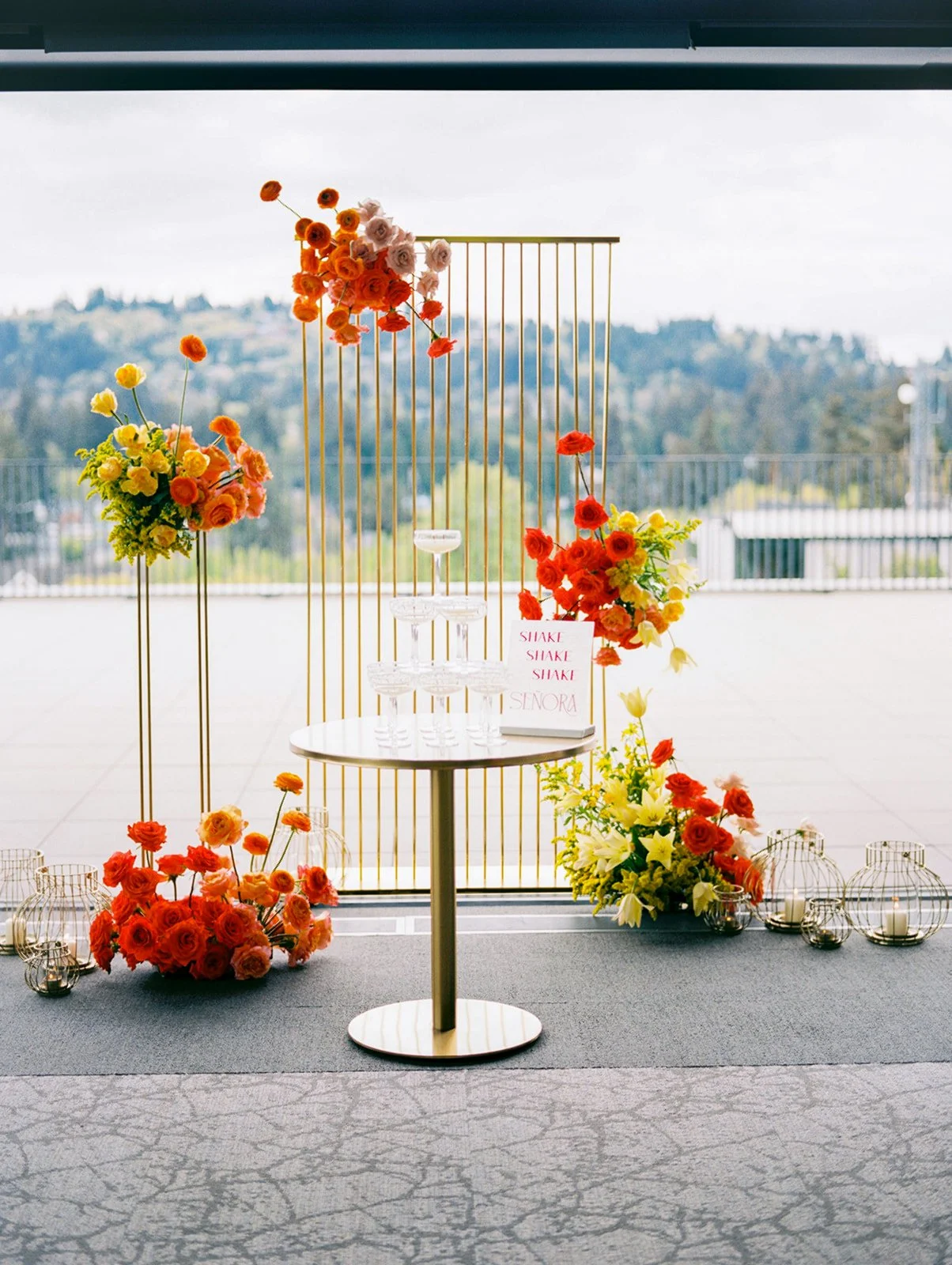 Margarita tower display with colorful florals and modern gold backdrop at rooftop wedding venue