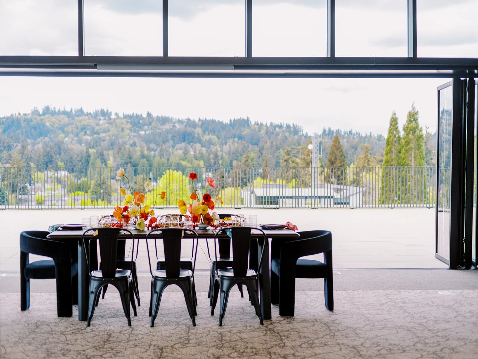 Reception table with colorful florals set against open-air view of Oregon landscape
