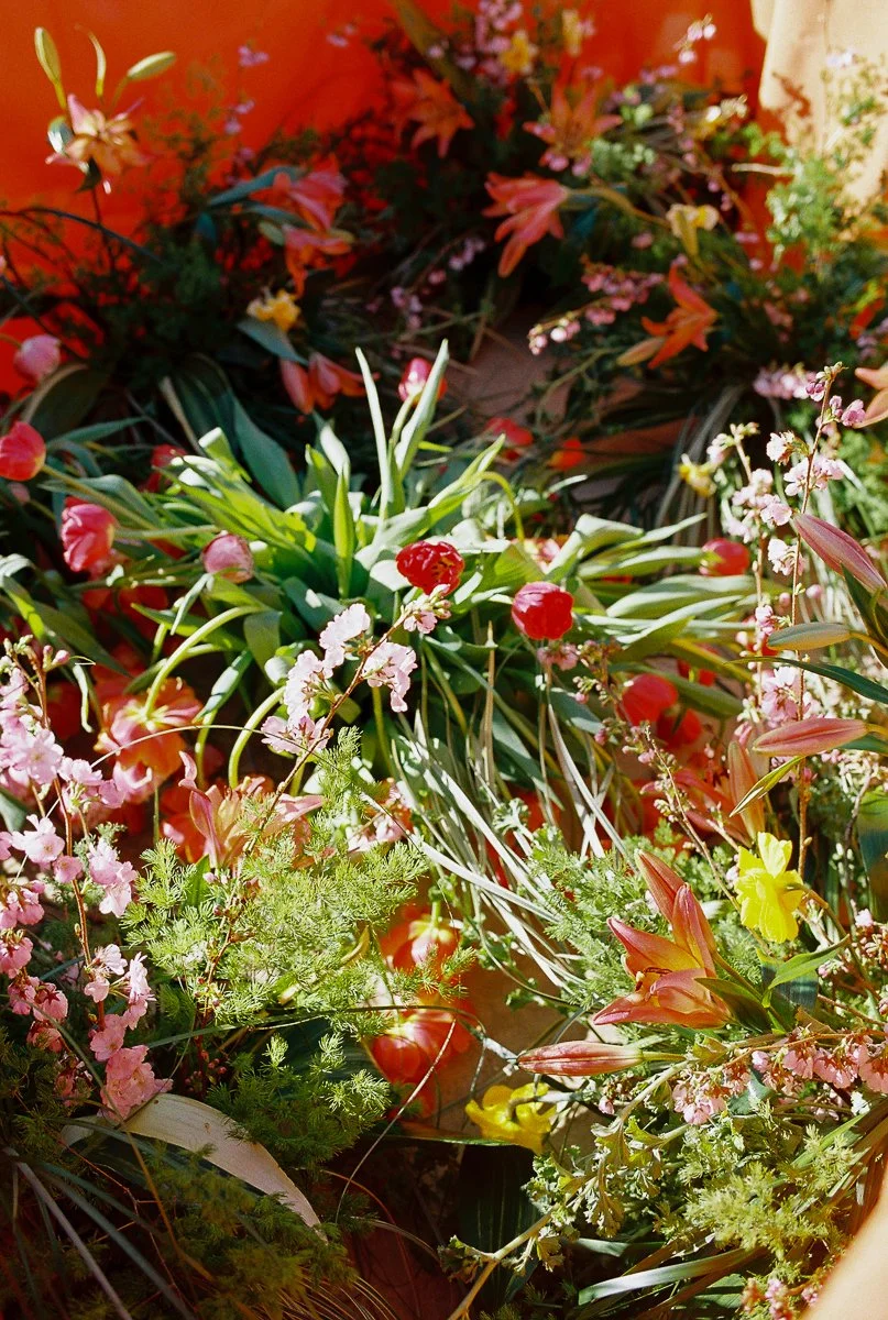 Overhead view of colorful floral reception installation with tulips, lilies, and spring blooms