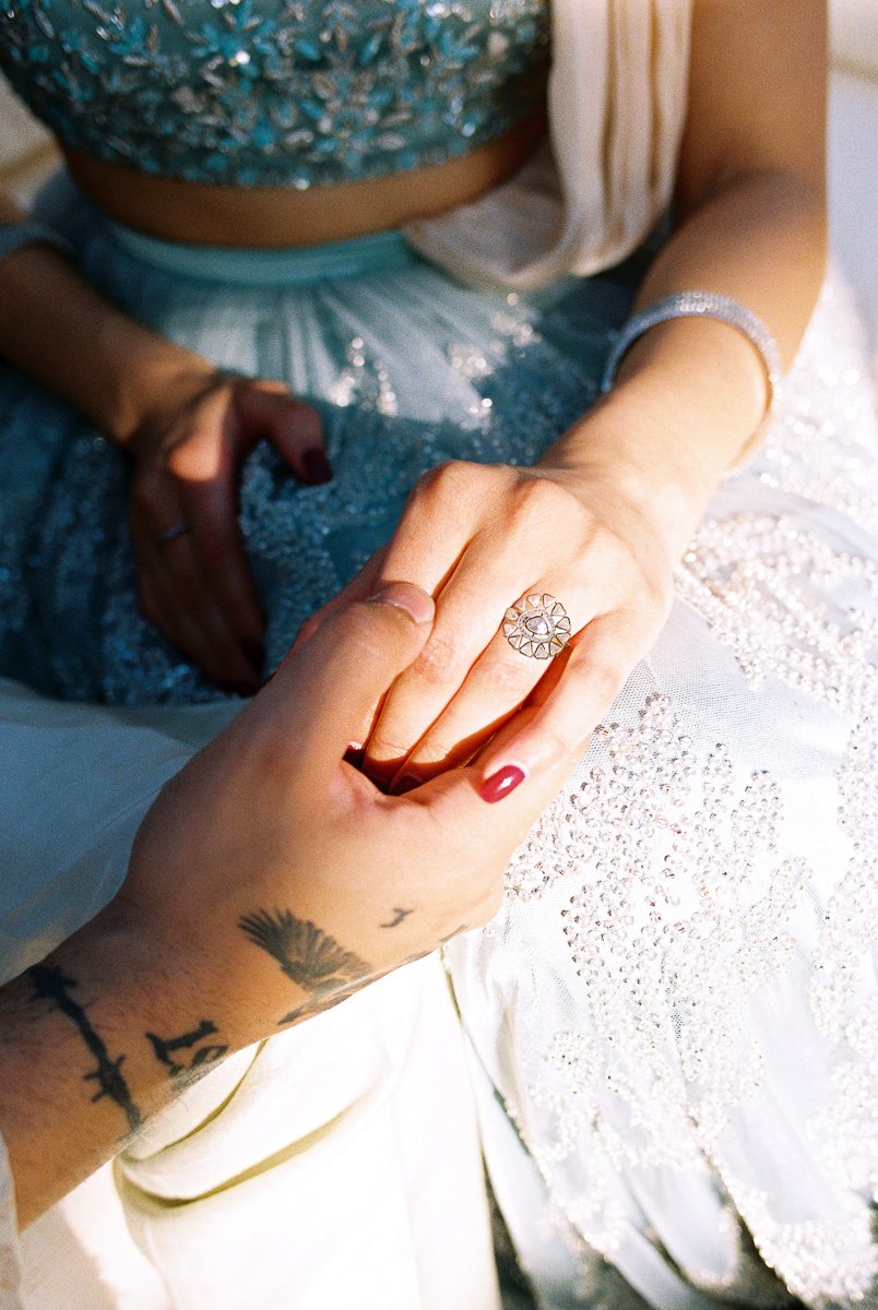 Close-up of hands holding during South Asian wedding portrait session with diamond ring detail.