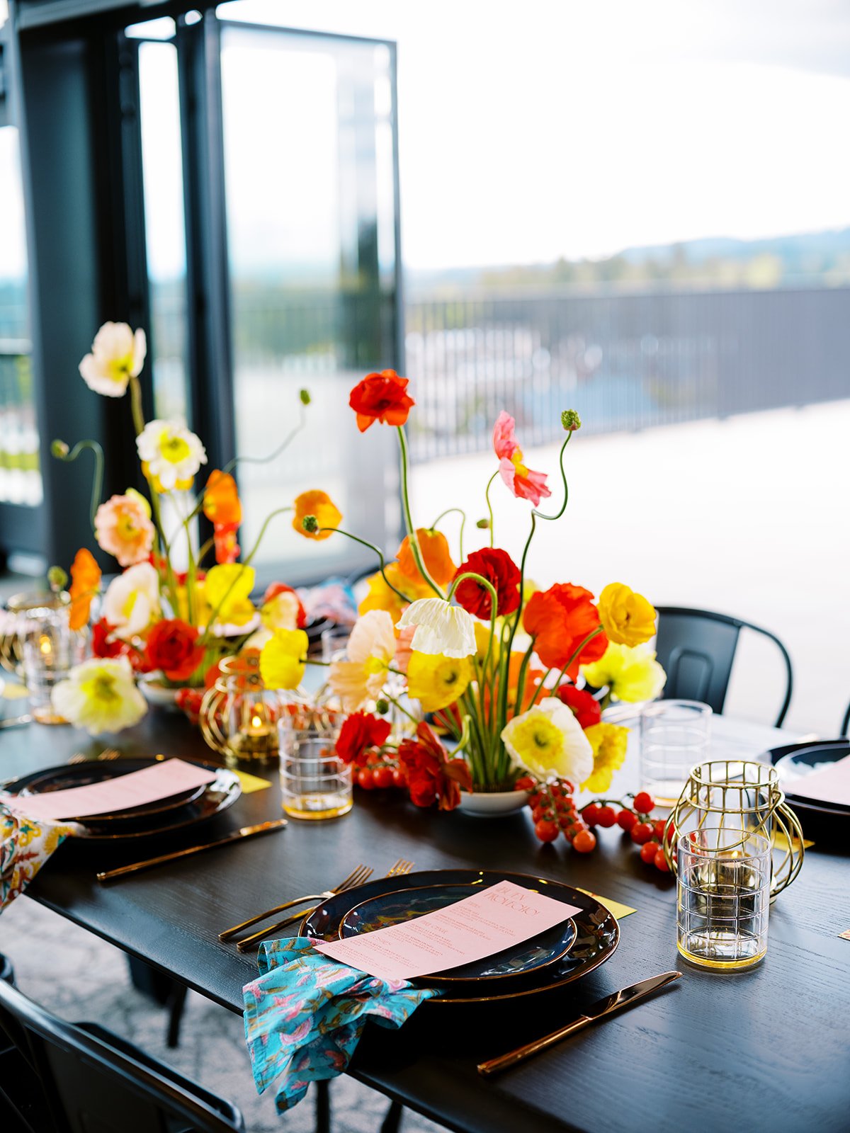 Colorful wedding reception table with red, orange, yellow, and white flowers at Ironlight in Oregon.
