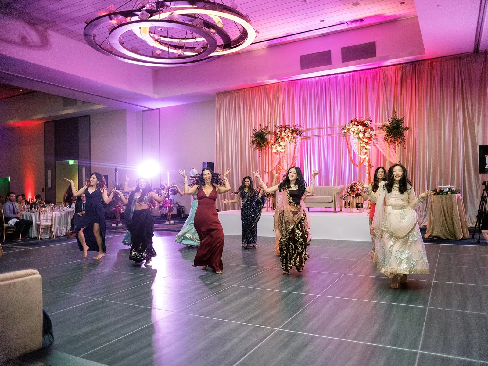 Wedding guests performing a group dance at a colorful Hyatt Regency Portland reception.