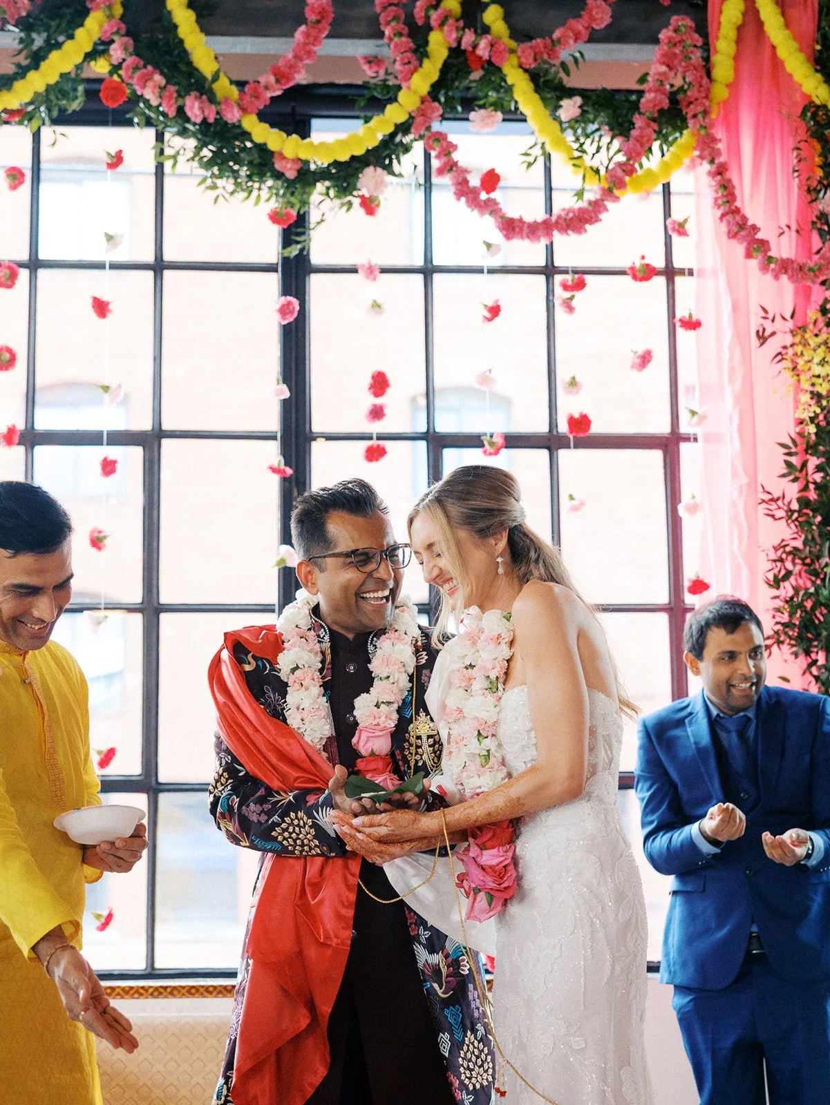 Wedding couple wearing floral garlands during a colorful ceremony at Castaway Portland.