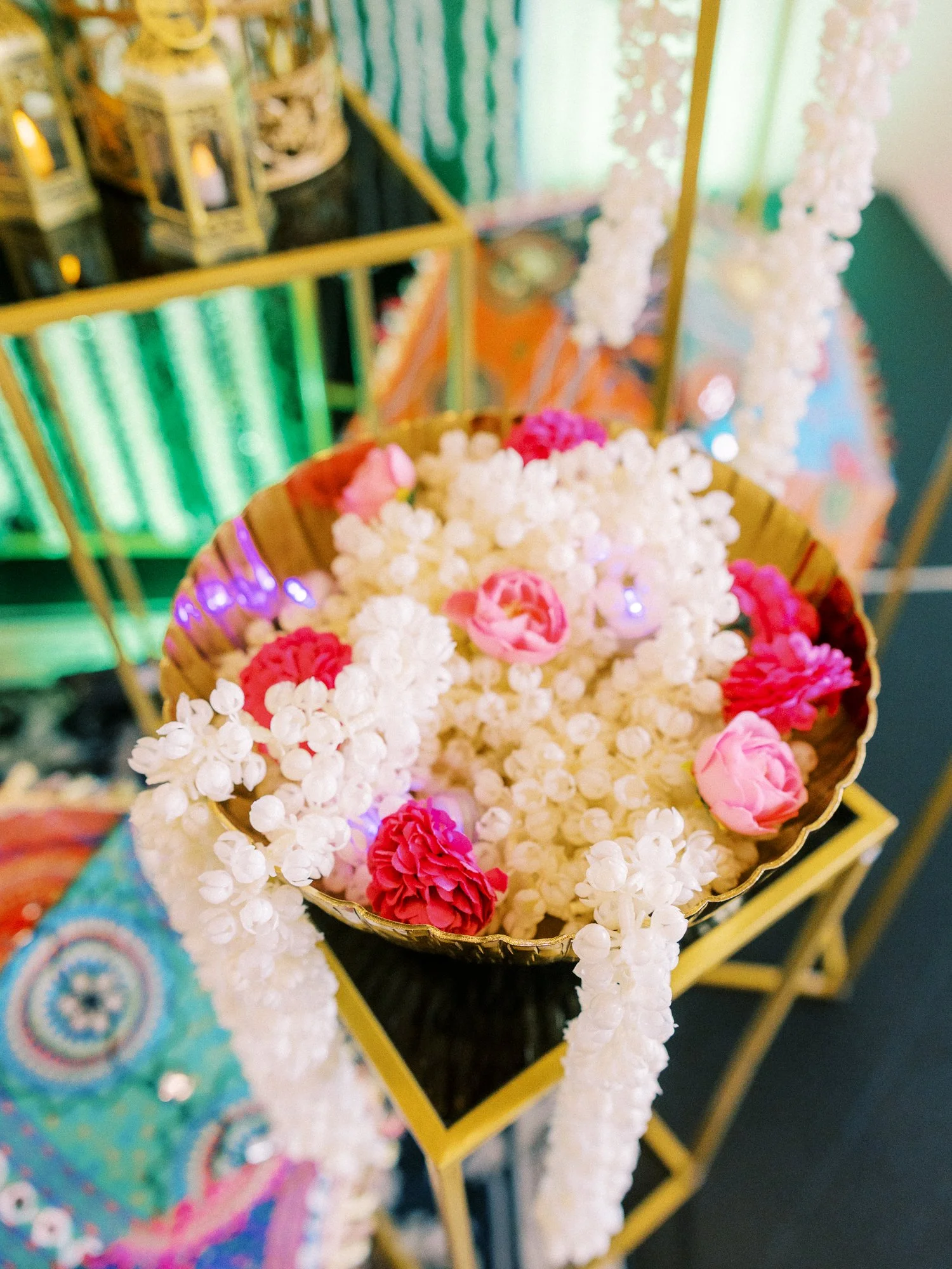Gold bowl filled with white and pink floral garlands as part of the Mehndi ceremony decor.
