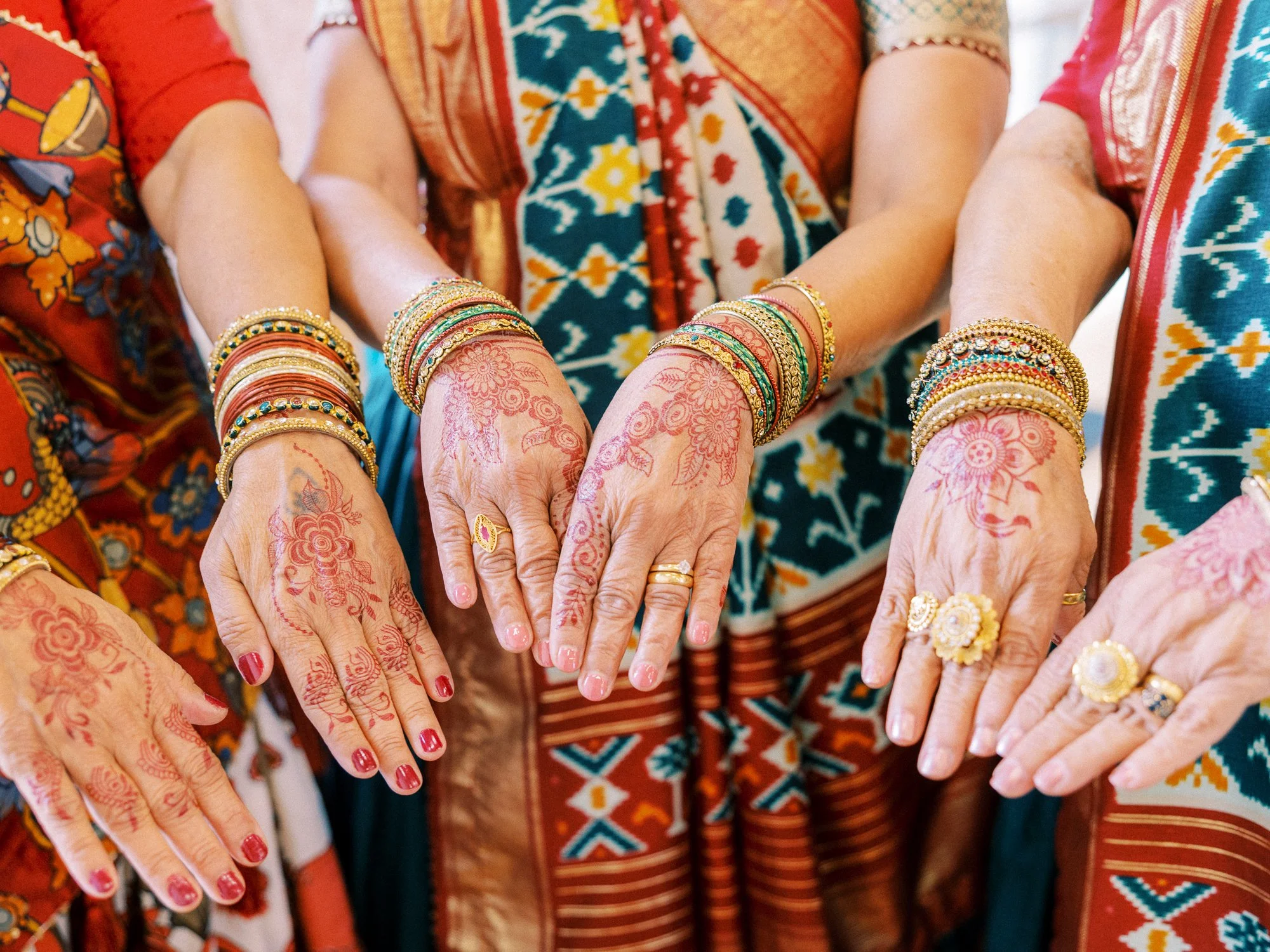 Guests display floral henna designs, colorful bangles, and rings during the Mehndi ceremony.