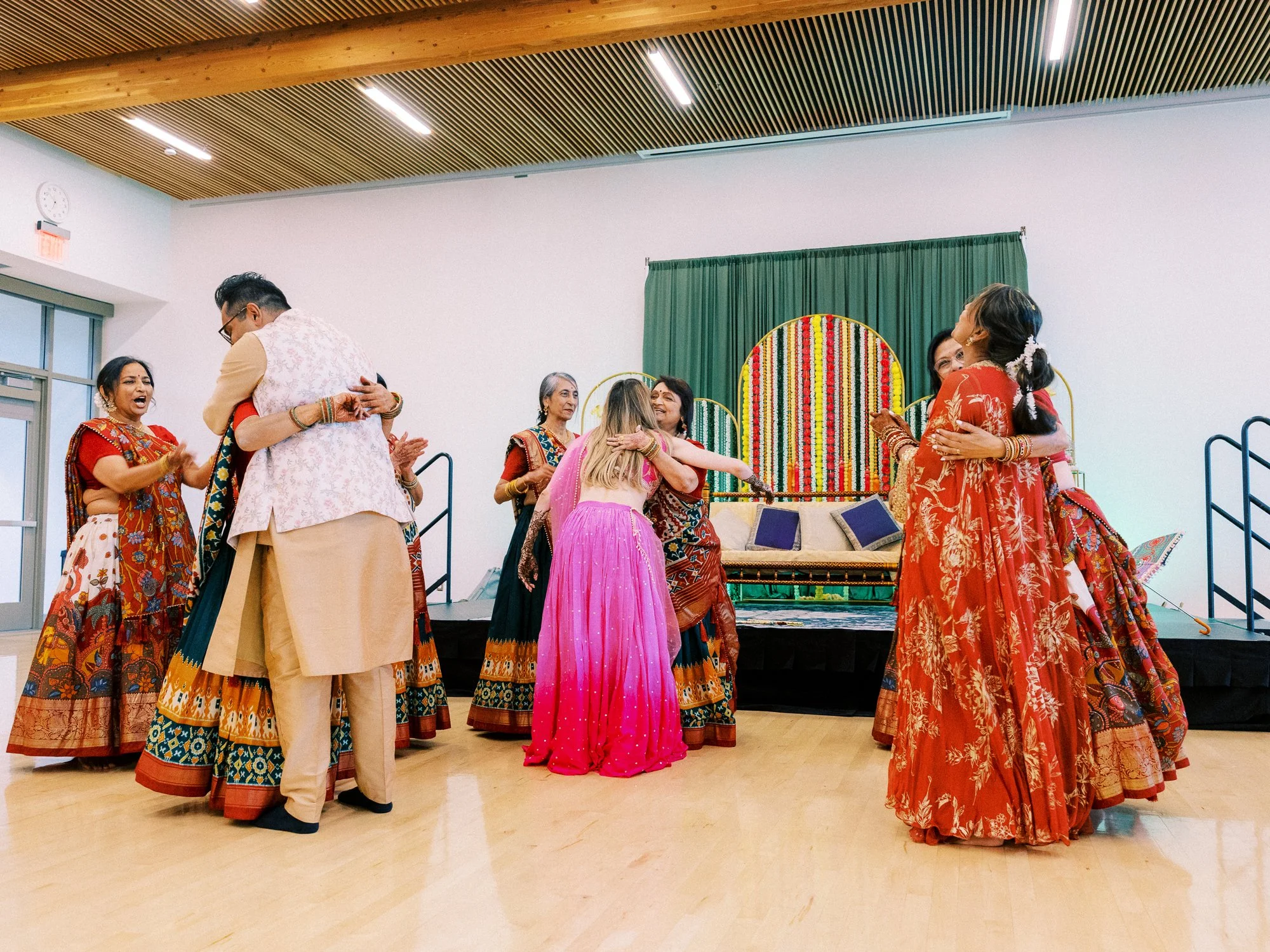 Alacia, Rohit, and guests exchange hugs after a group dance at the Mehndi celebration.