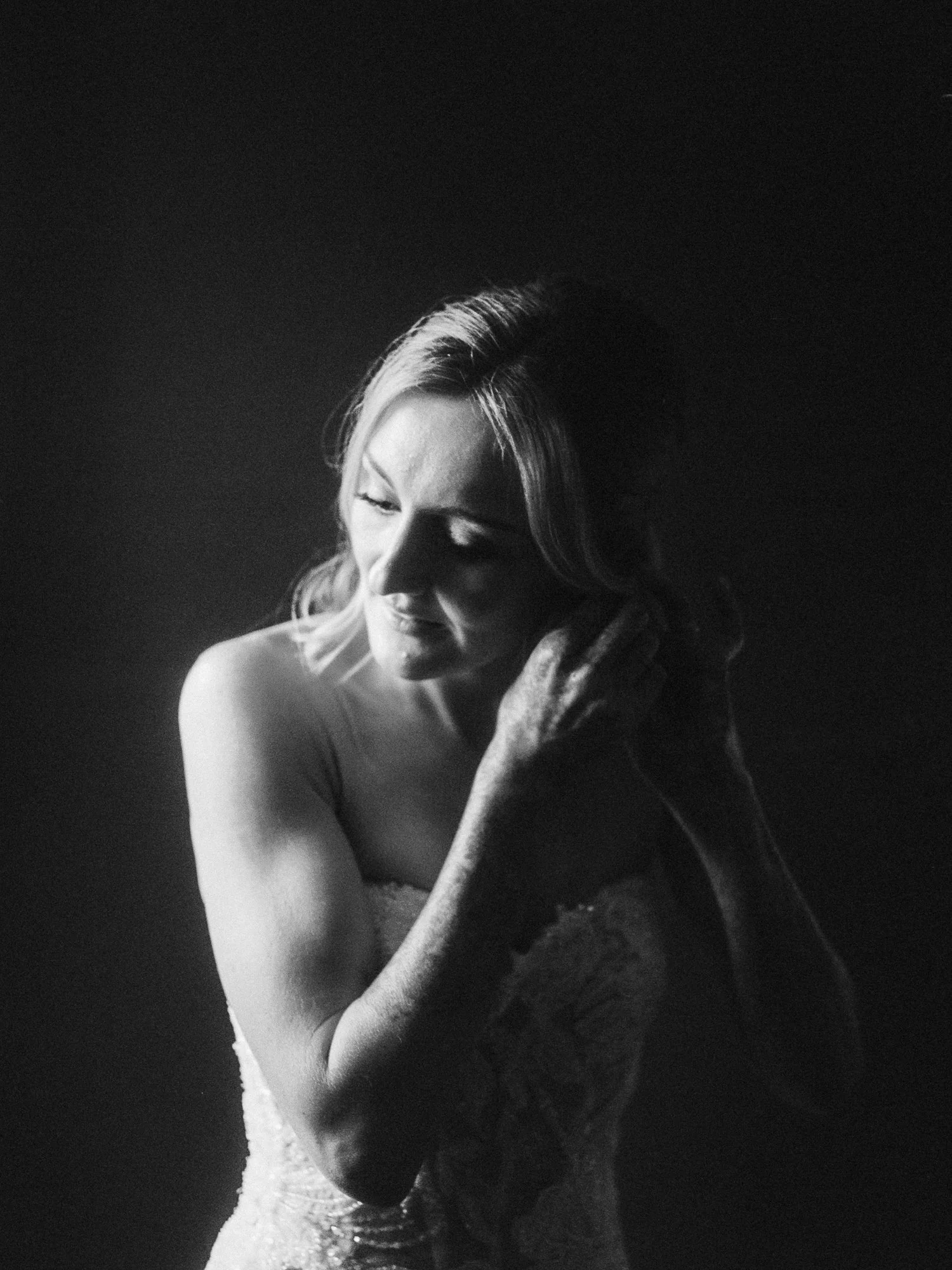 Black-and-white bridal portrait of Alacia adjusting her hair while getting ready at the Sentinel Hotel.