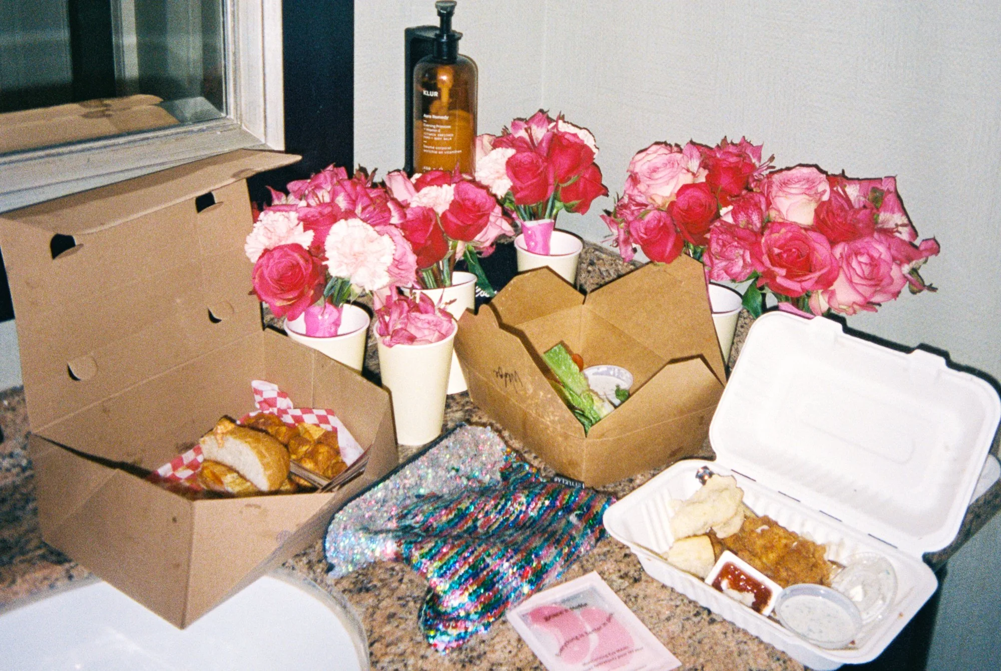 Wedding morning details with pink flowers, takeout boxes, and accessories arranged in the Sentinel Hotel room.