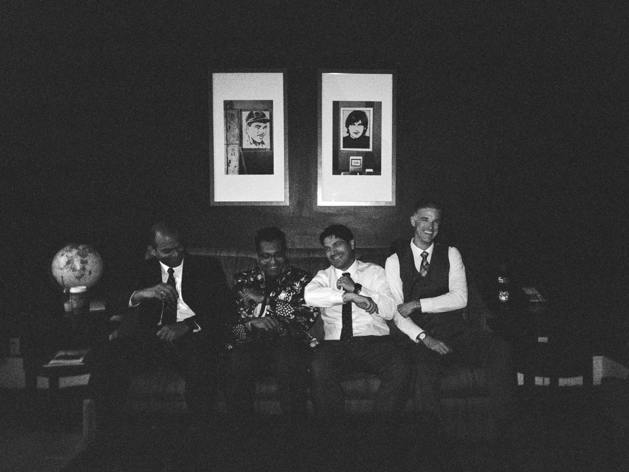 Wedding party members sit together in a dimly lit lounge at the Sentinel Hotel before the ceremony.