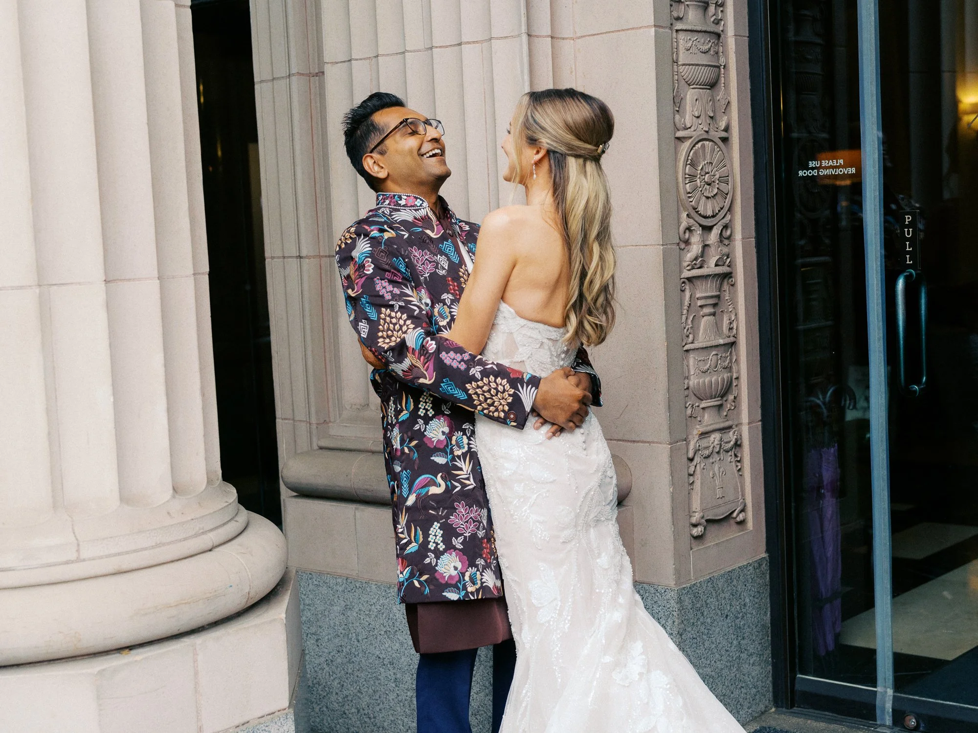 Bride and groom share their first-look moment outside the Sentinel Hotel’s historic stone entrance in Portland.
