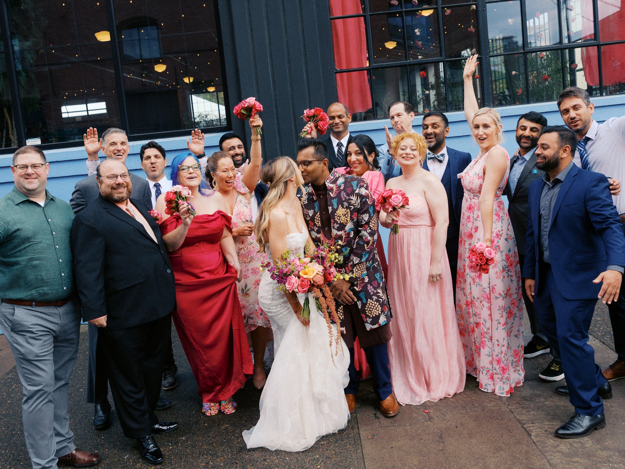 Bride and groom kiss surrounded by their wedding party outside Castaway Portland after the