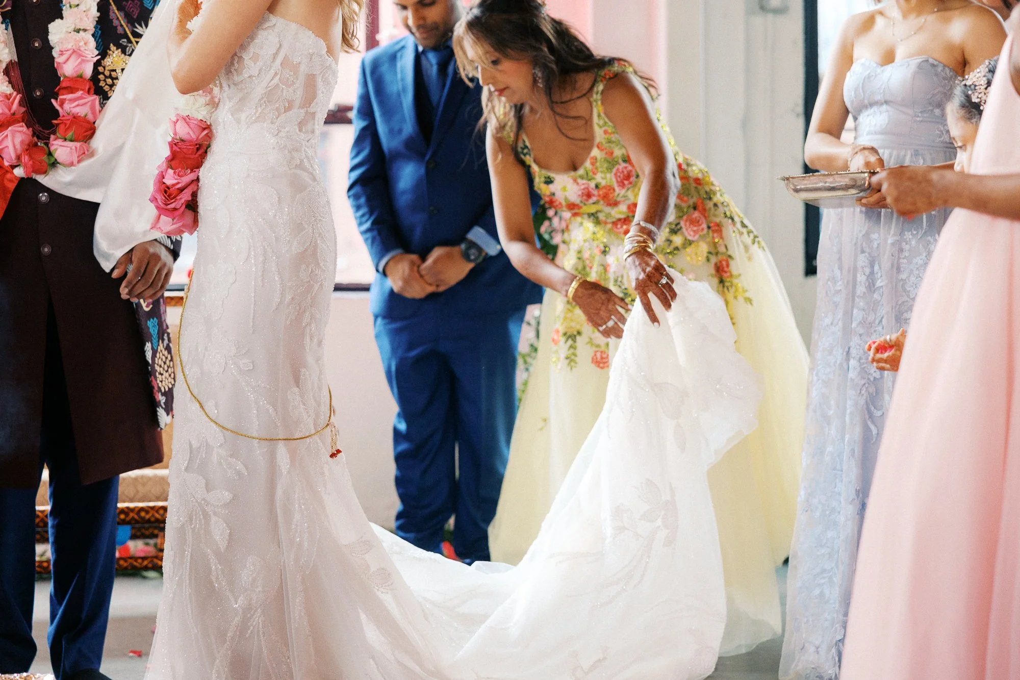 Wedding attendants adjust the bride’s train during the ceremony at Castaway Portland.