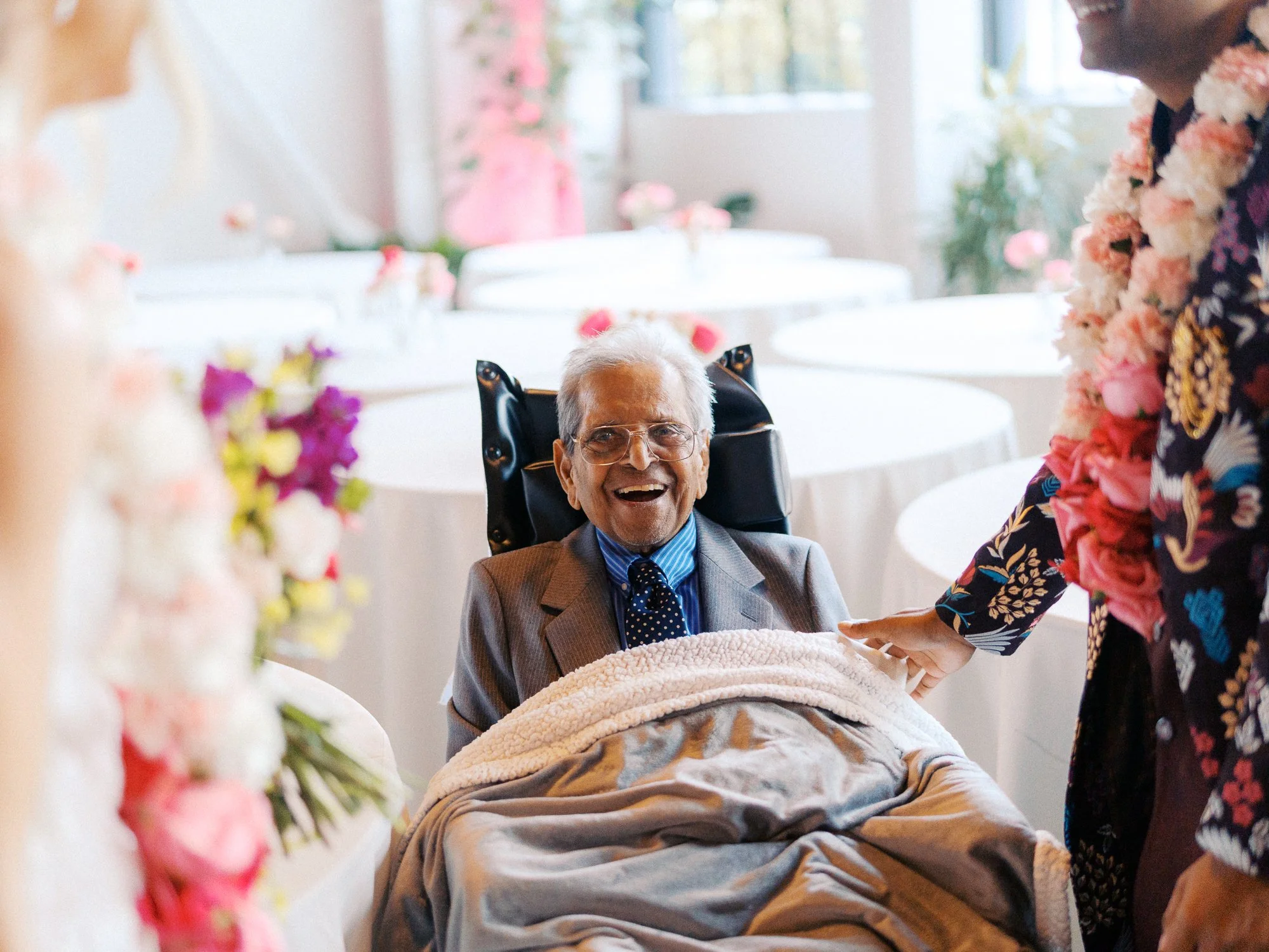 Elderly guest smiles toward the newlyweds during the post-ceremony celebration.