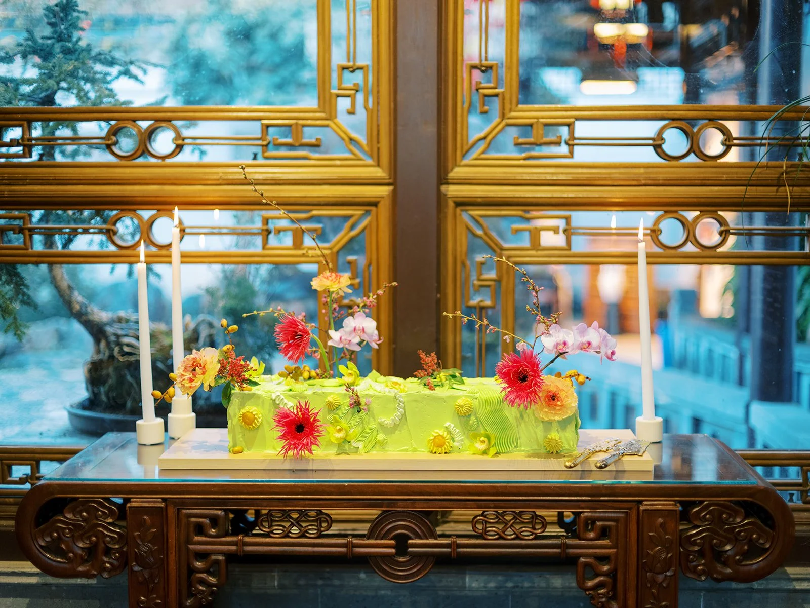 Floral decorated green cake displayed on an ornate table at Lan Su Chinese Garden during a bachelorette event.