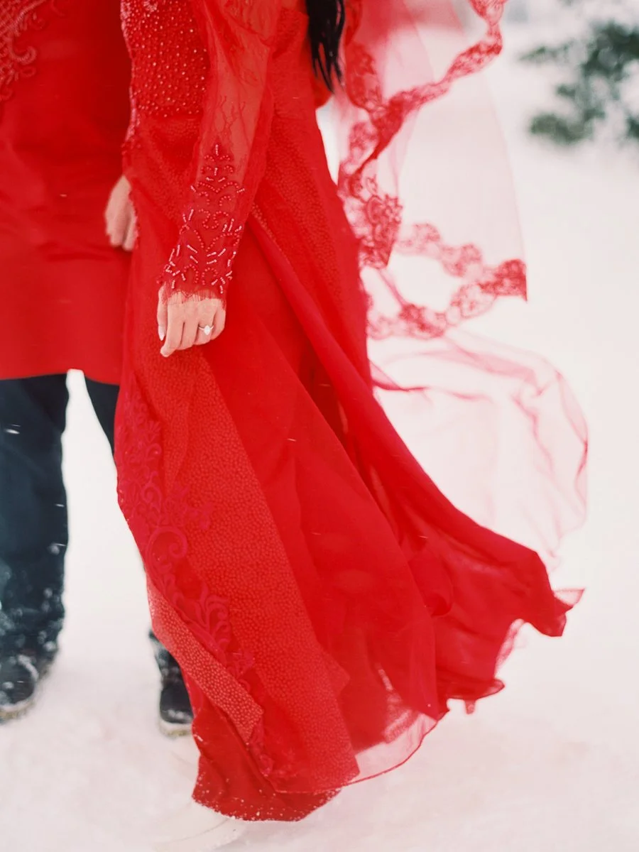 Flowing red Vietnamese áo dài fabric moving through snow during Mount Hood portrait session.
