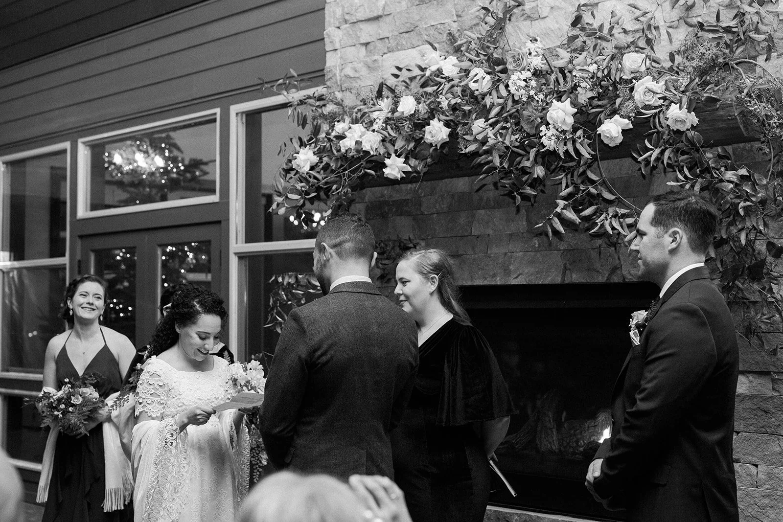 Black-and-white photograph of the bride reading her vows to the groom during their intimate ceremony.