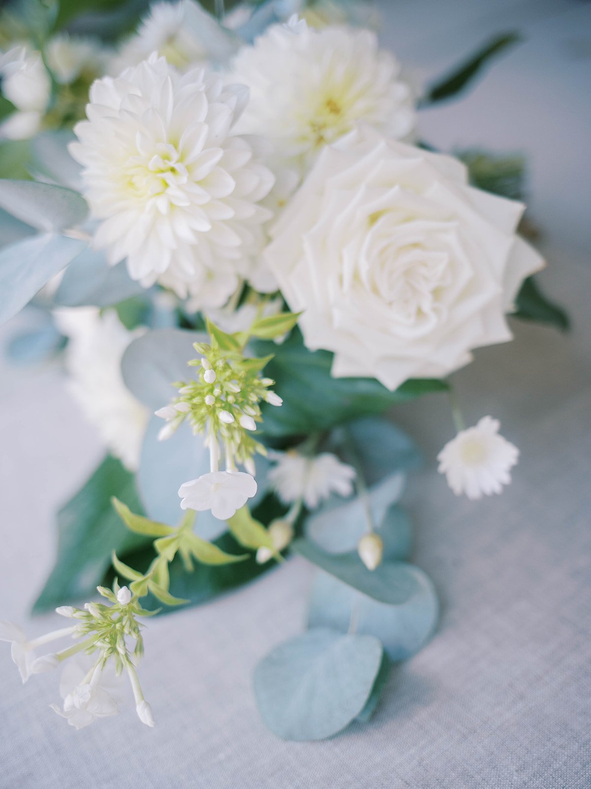 White bridal bouquet with roses, dahlias, and eucalyptus in soft natural light at Abigail’s Garden wedding.