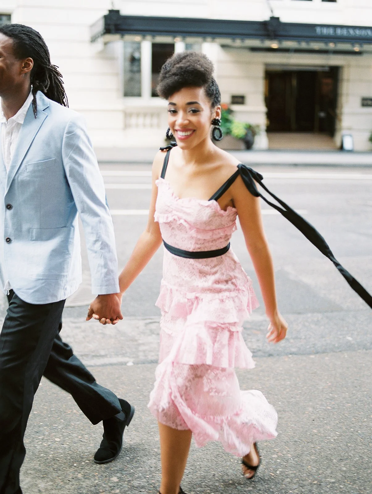 Close-up of couple holding hands while walking through Portland city street