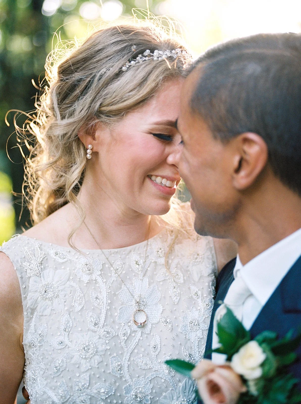 Close-up of the bride and groom touching foreheads in warm afternoon light.
