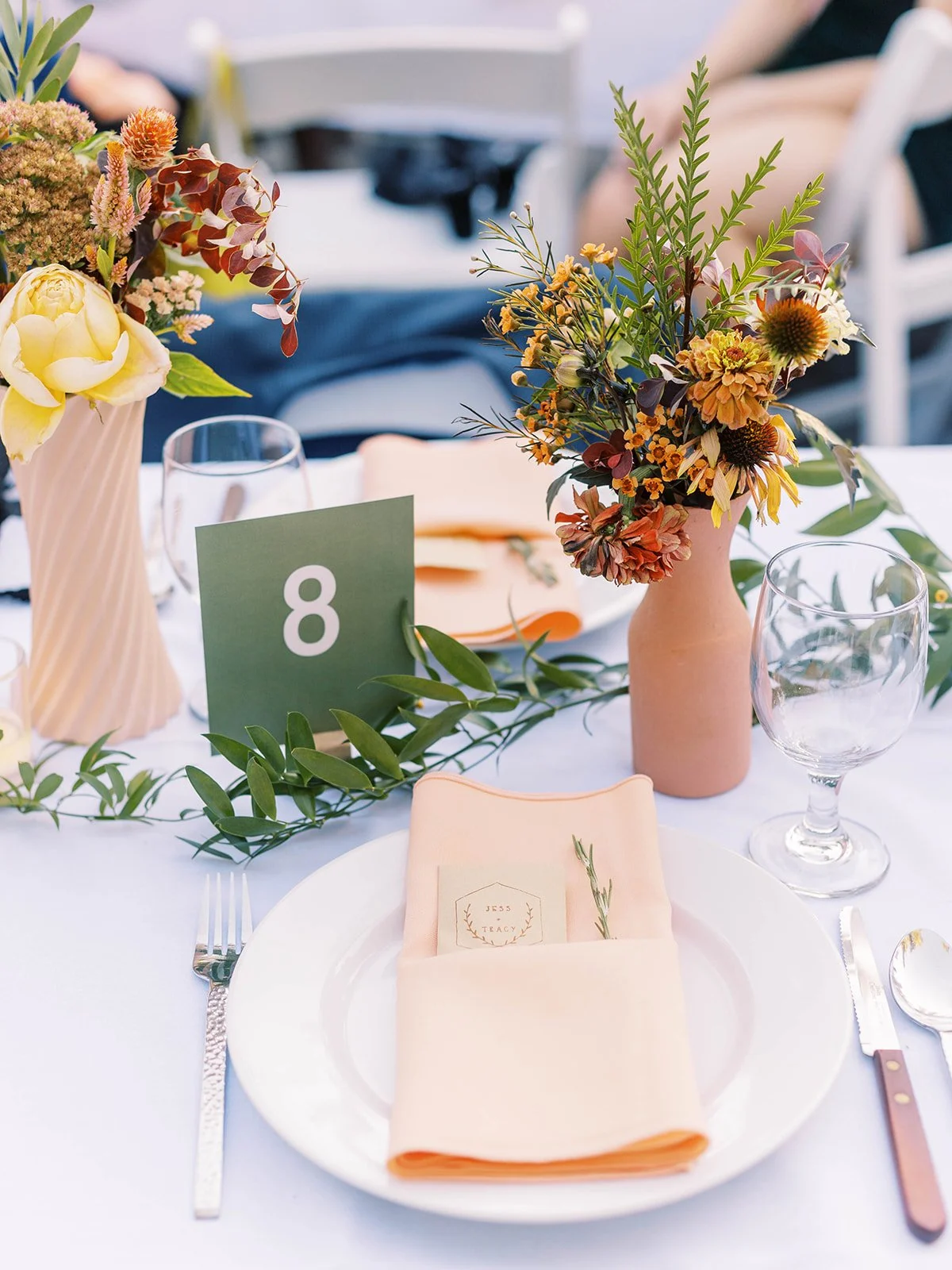 Wedding table setting with floral centerpiece, table number, and place setting details
