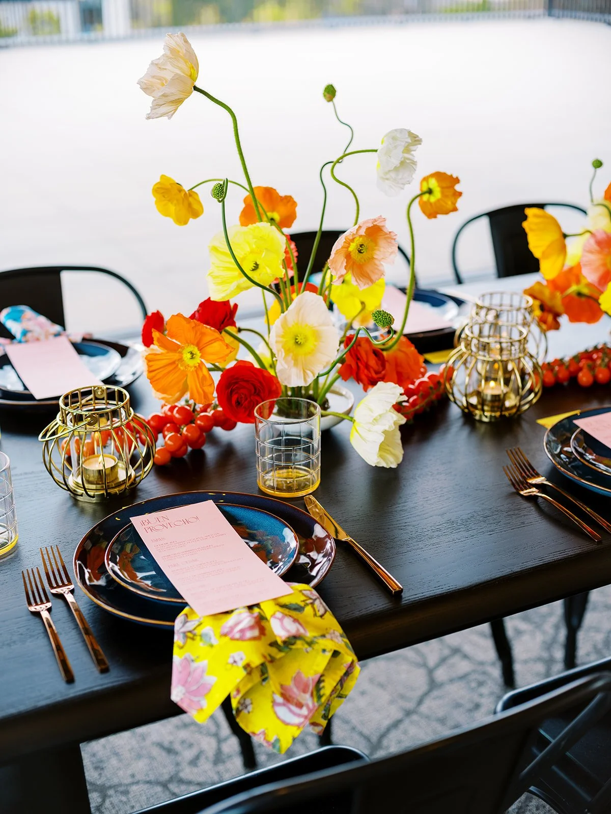 Modern wedding reception table with vibrant flowers, gold flatware, and patterned napkins at Ironlight venue
