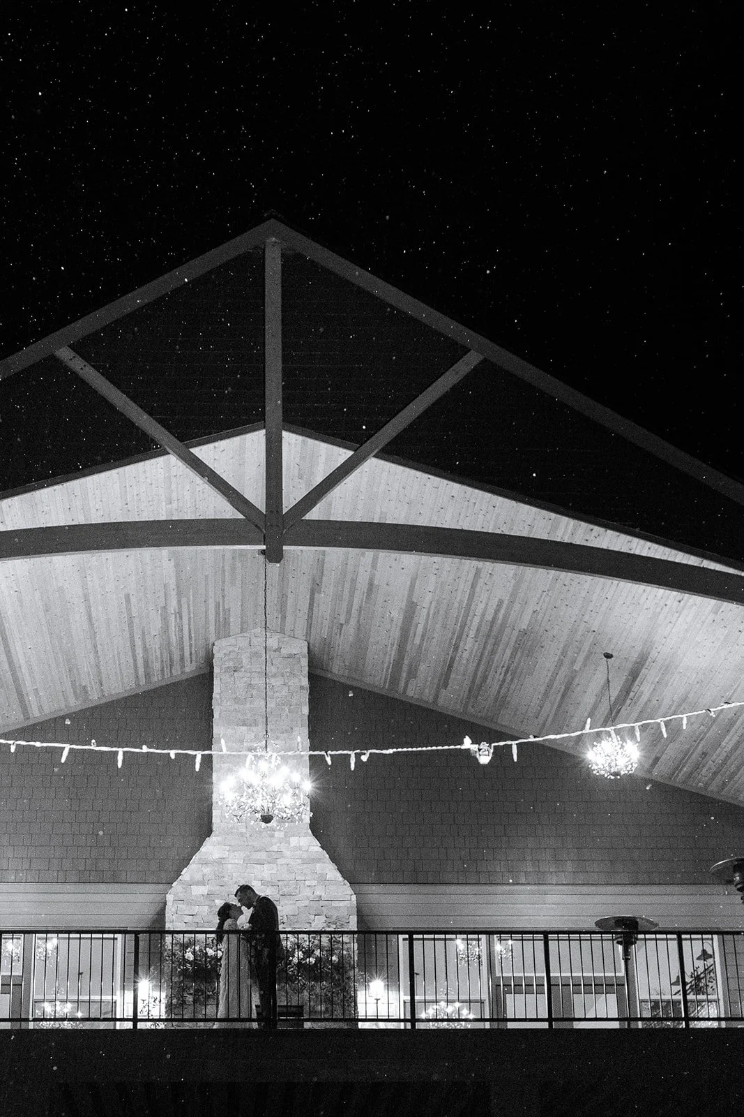 Bride and groom beneath a covered pavilion and string lights during their intimate Oregon wedding at night.