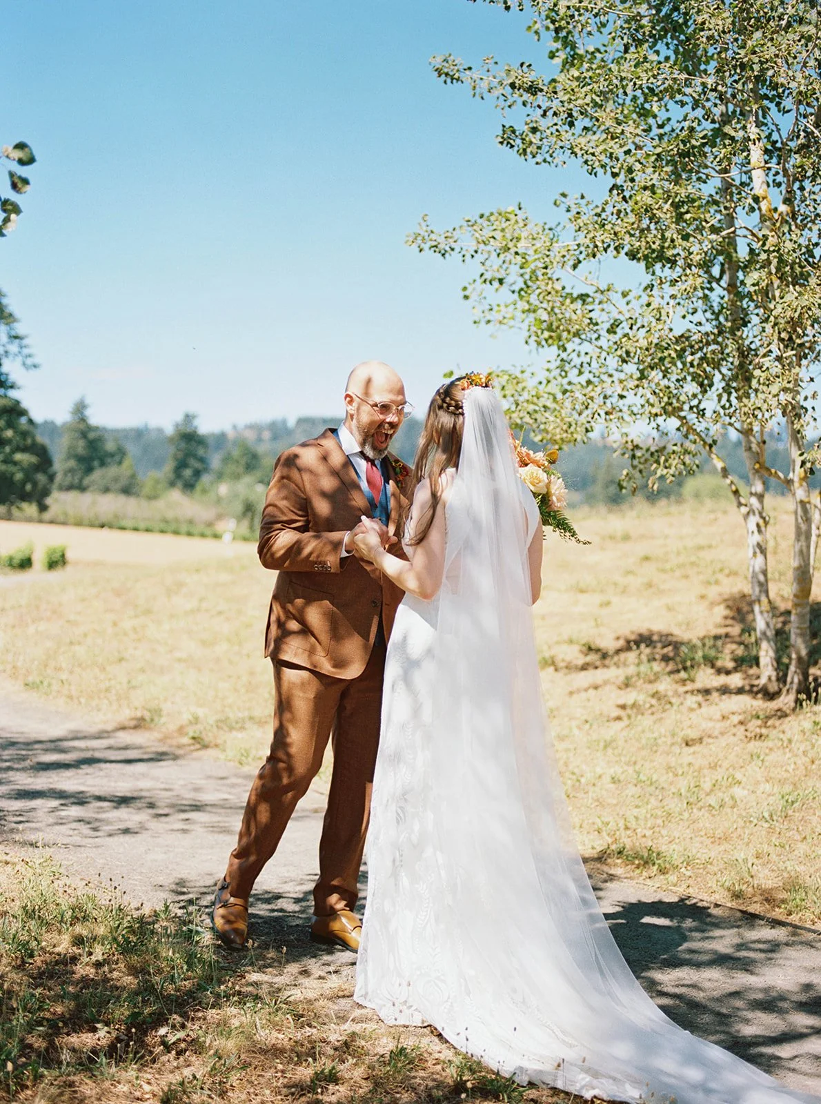 Bride and groom meeting on path, holding hands during first look in outdoor setting