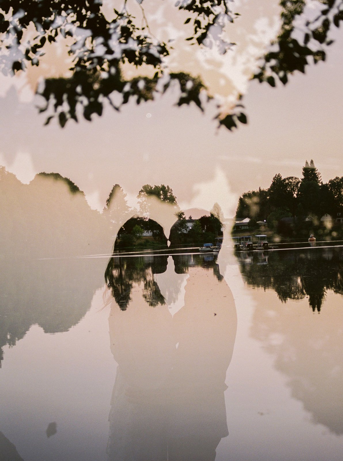 Double exposure of couple kissing over a lake at sunset, artistic Oregon engagement photo
