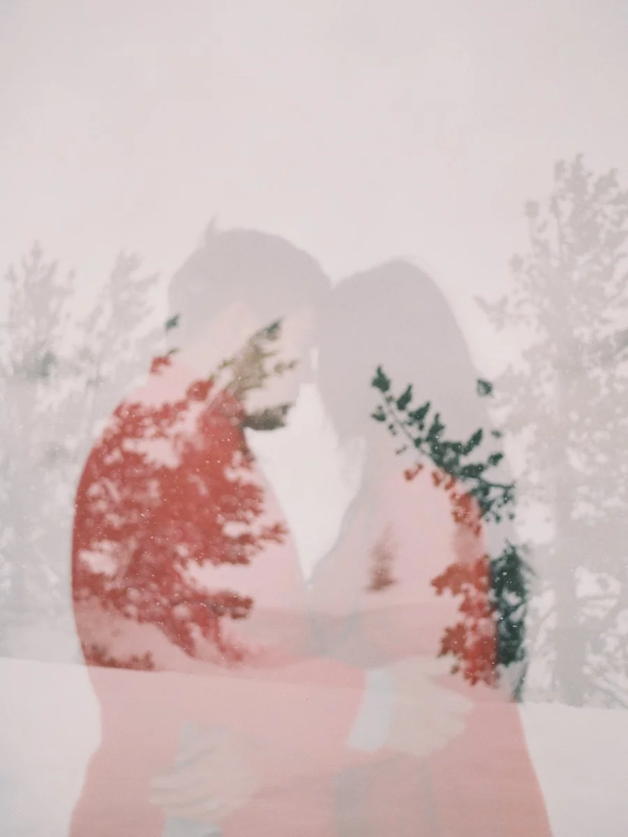 Silhouetted couple in Vietnamese áo dài with double exposure of snowy trees at Mount Hood.