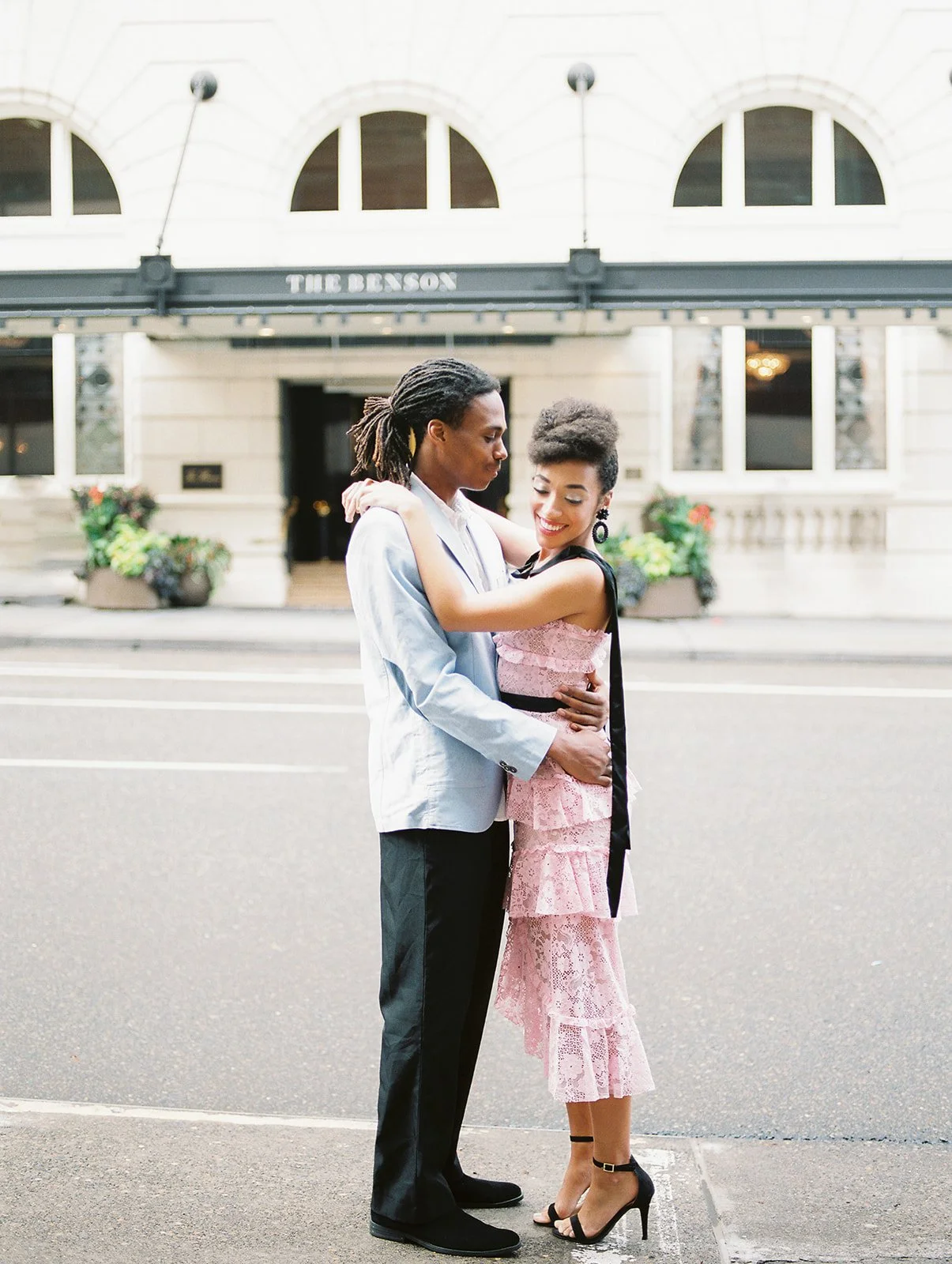 Couple embracing in the street outside The Benson Hotel in downtown Portland