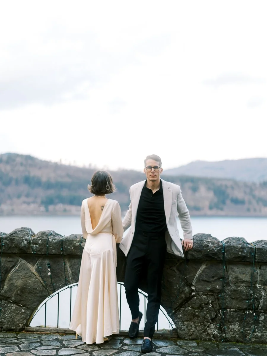 Couple standing along stone wall overlooking Columbia River Gorge at Columbia Gorge Hotel