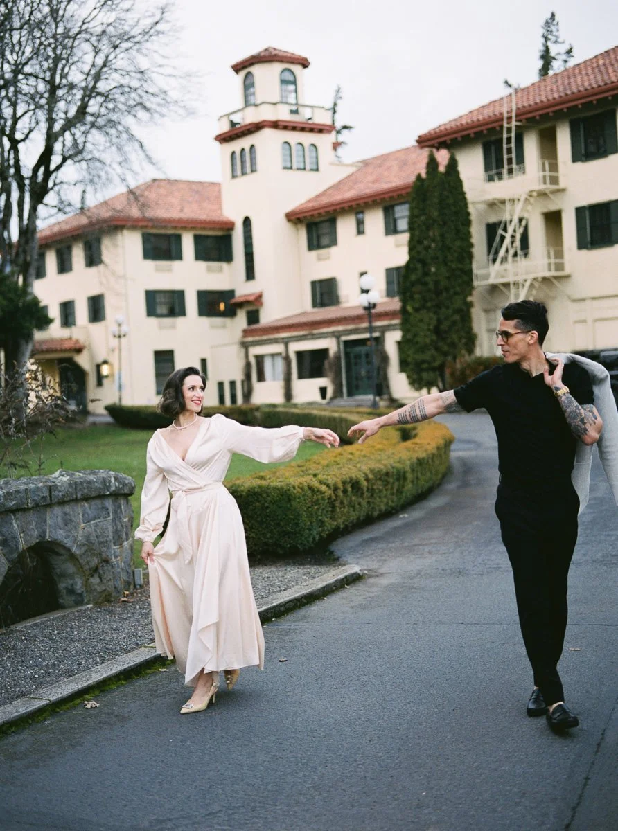 Couple walking playfully in front of Columbia Gorge Hotel in Hood River Oregon
