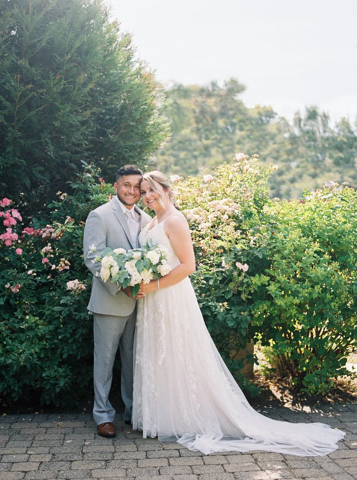 Bride and groom portrait in blooming garden at Abernathy Center with soft summer florals.