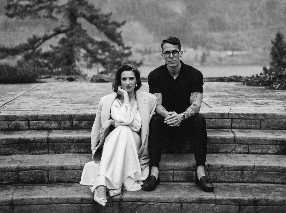 Black and white film portrait of an anniversary couple seated on stone steps at the Columbia Gorge Hotel, styled in an editorial, romantic Oregon setting.