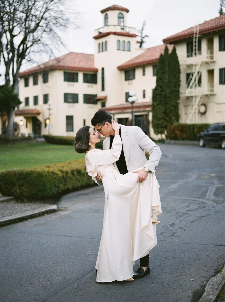 Couple embracing in front of Columbia Gorge Hotel during romantic engagement session