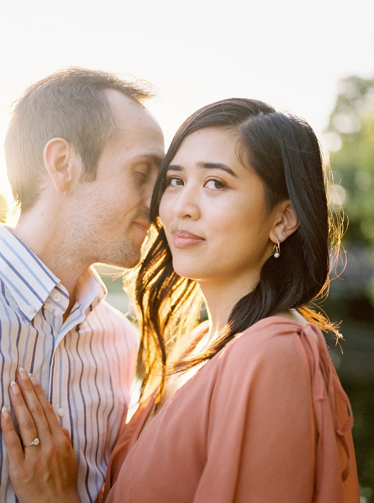Close-up of couple touching foreheads in warm sunset light by the lake in Oregon