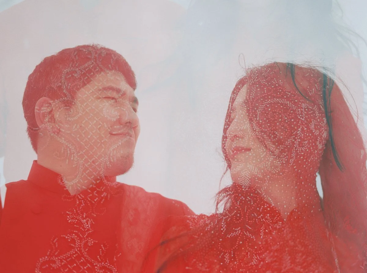 Double exposure of couple in red Vietnamese áo dài with intricate embroidery layered over snowy Mount Hood scene.